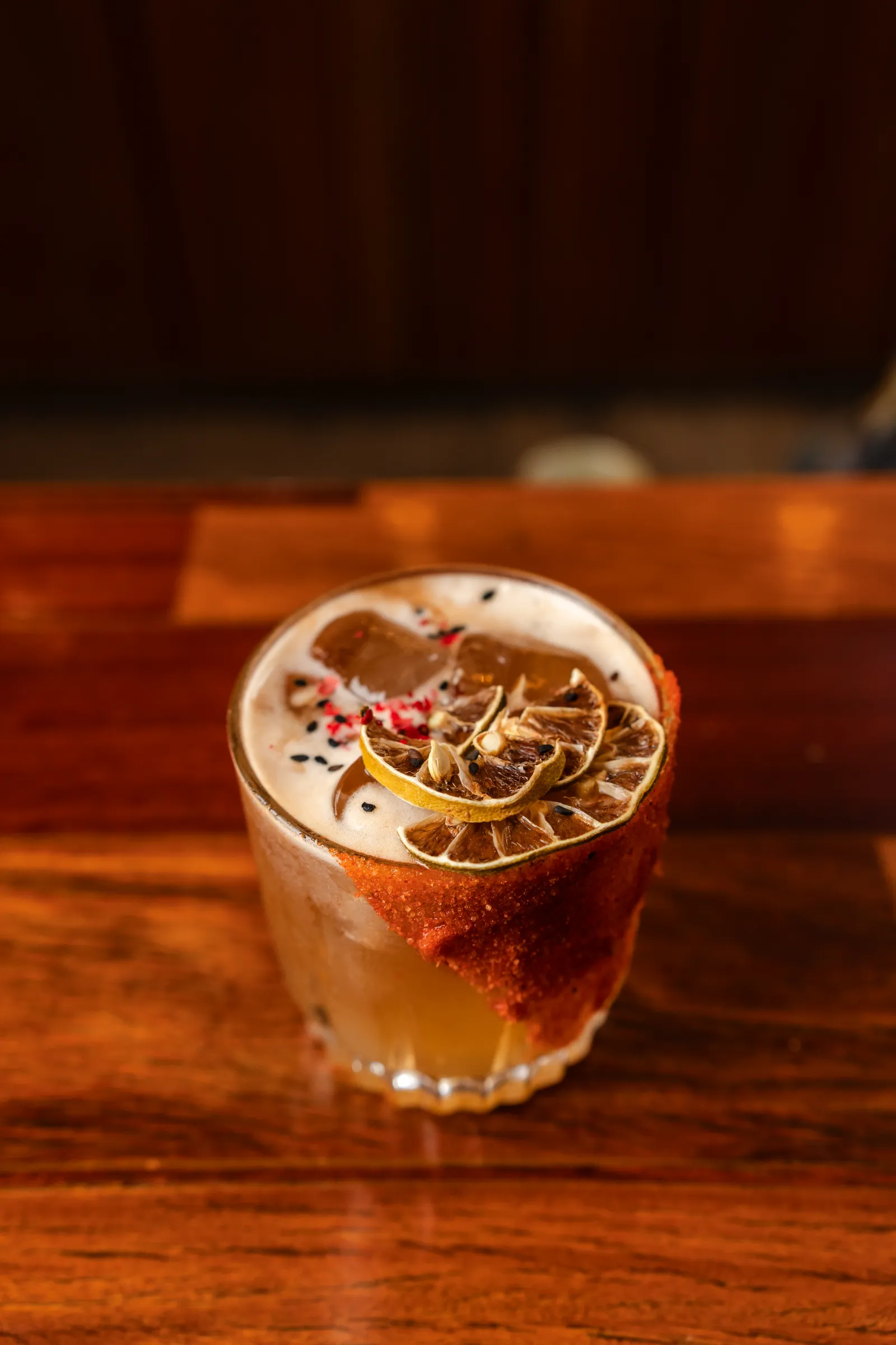 A cocktail with a spice-salt rim and dehydrated citrus