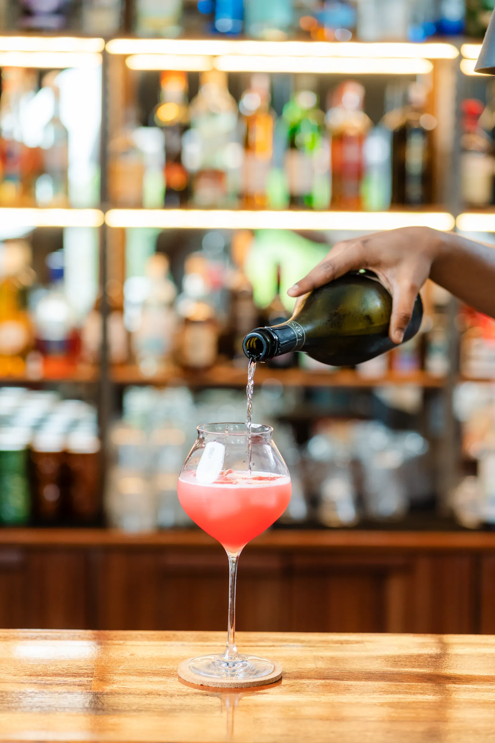 Prosecco poured into a pink cocktail at the Amigo bar